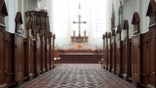 The aisle in a Christian church looking toward the cross