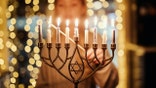 woman lighting Menorah candles