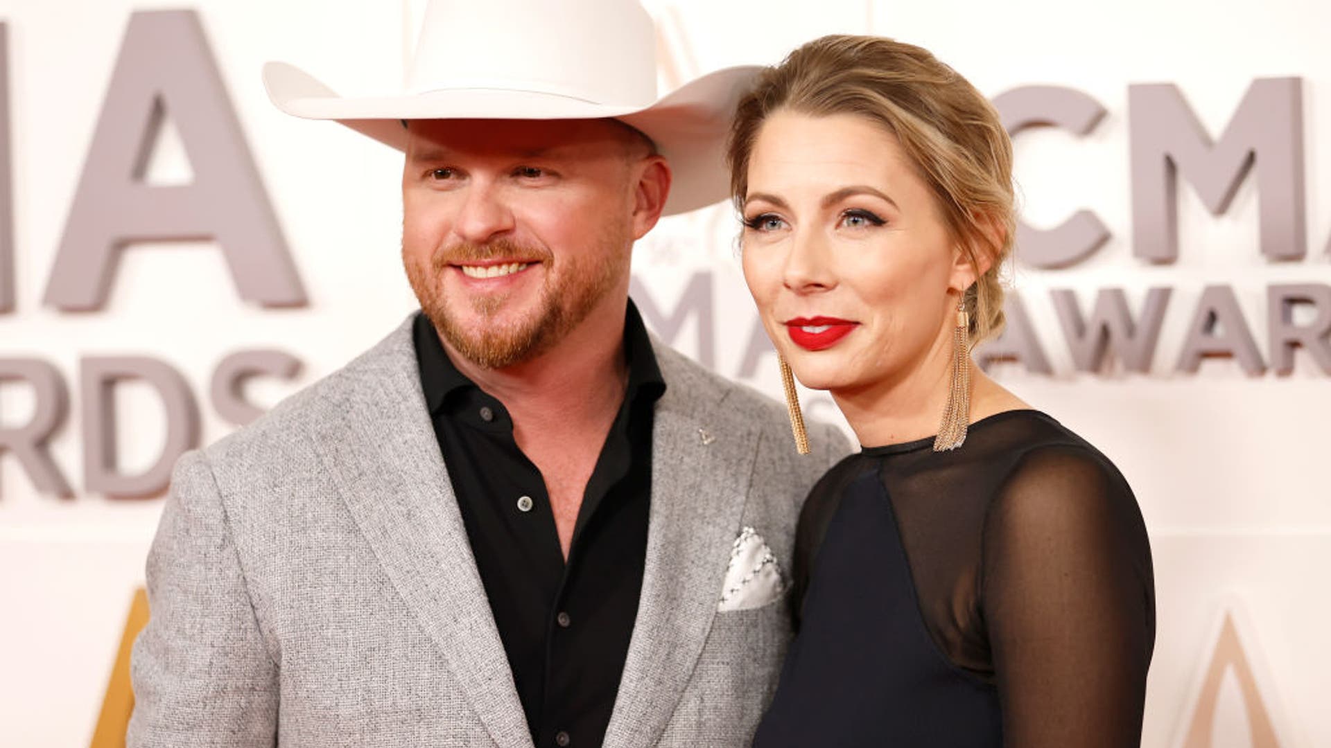 Cody Johnson and Brandi Johnson are all smiles on the carpet.