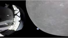 NASA space capsule rounds the moon