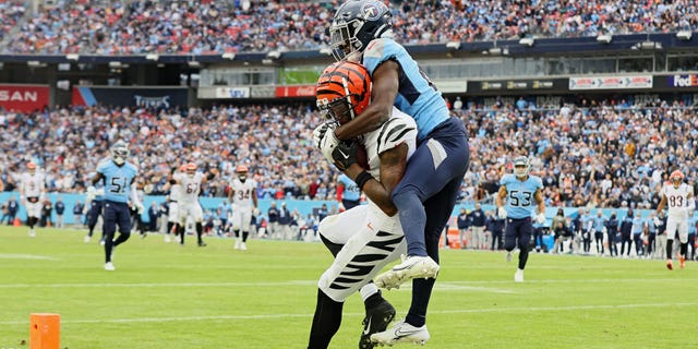 Tee Higgins #85 dari Cincinnati Bengals menangkap bola untuk mencetak gol saat Roger McCreary #21 dari Tennessee Titans bertahan selama kuarter keempat di Nissan Stadium pada 27 November 2022 di Nashville, Tennessee.