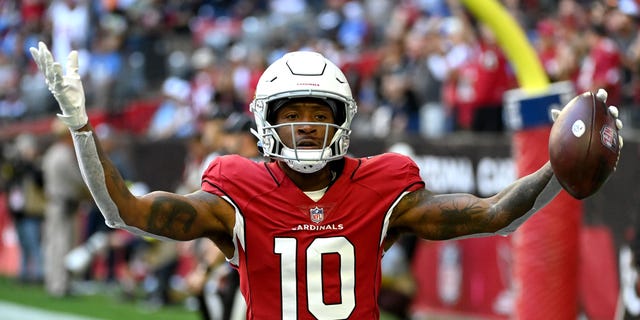 Arizona Cardinals' DeAndre Hopkins #10 celebrates after scoring a touchdown in the first quarter of a game against the Los Angeles Chargers at State Farm Stadium on November 27, 2022, in Glendale, Arizona.