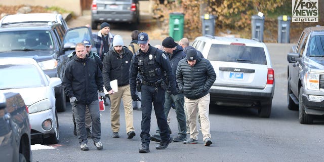Police oversee the removal of trash in front of the home where four University of Idaho students were killed over the weekend, Tuesday, November 15, 2022.