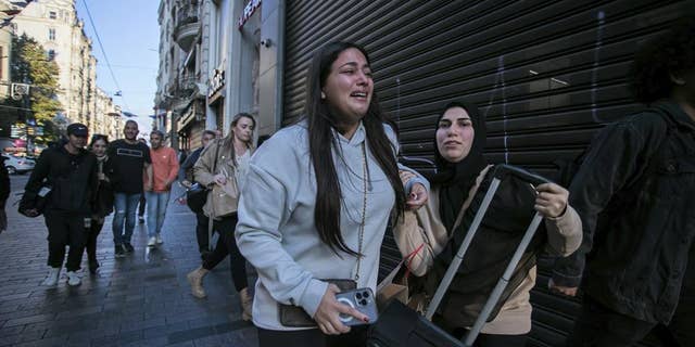 People leave the area after an explosion on Istanbul's popular pedestrian Istiklal Avenue Sunday, Istanbul, Sunday, Nov. 13, 2022. A bomb exploded on a major pedestrian avenue in the heart of Istanbul on Sunday, killing a handful of people, wounding dozens and sending people fleeing as flames rose.