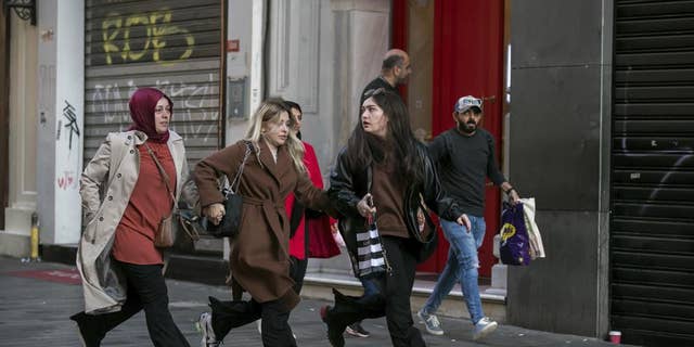 People leave the area after an explosion on Istanbul's popular pedestrianized Istiklal Avenue on Sunday, Istanbul, Sunday 13 November 2022. A bomb exploded Sunday on a major pedestrian street in the heart of Istanbul, killing a handful of people, injuring dozens and sending people on the run as the flames rose.