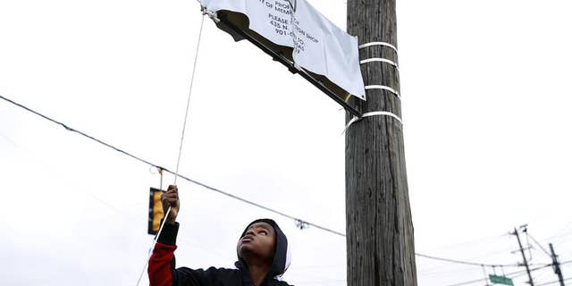 Young Dolph's son, Tre Tre, helps unveil a new street sign at a street naming ceremony honoring Young Dolph in Memphis, Tenn., Dec. 15, 2021.