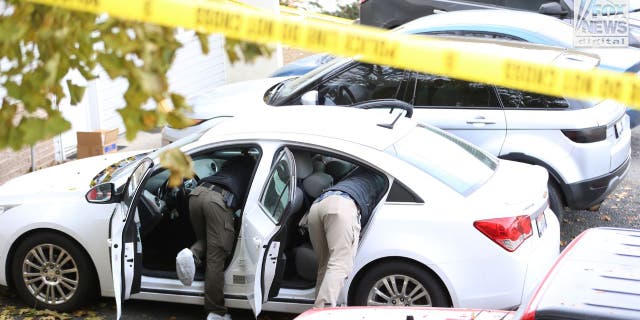 Investigators search a vehicle near the scene of a Nov. 13 quadruple homicide near the University of Idaho.