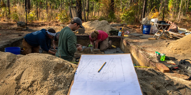 Archeologists cleaning Continental burials at the Battle of Camden site.