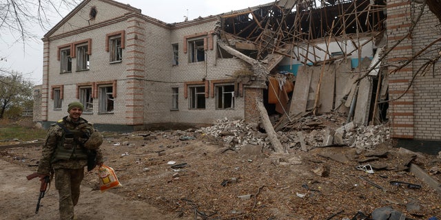 A Ukrainian military man passes an asylum building damaged during a Russian missile attack in the village of Novooleksandrivka, in the Kherson region of Ukraine, on November 9, 2022.  