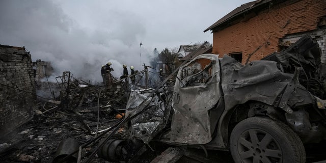 Rescuers work near houses heavily damaged by a Russian missile strike in Dnipro, Ukraine Nov. 26, 2022.