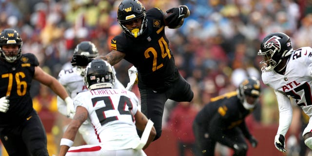 Antonio Gibson #24 of the Washington Commanders runs with the ball in the fourth quarter of a game against the Atlanta Falcons at FedExField on November 27, 2022 in Landover, Maryland.