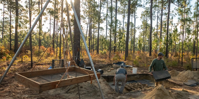 Archaeologists work at the Camden burial site.