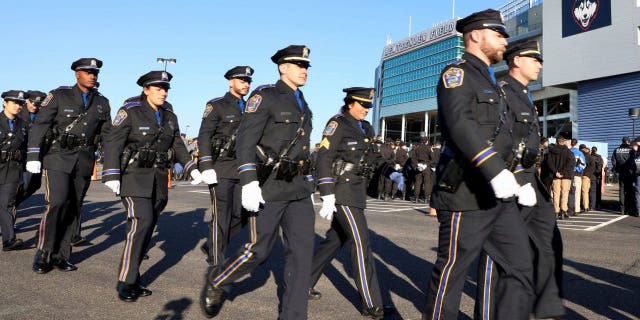 Police officers file into Pratt &amp;amp; Whitney Stadium at Rentschler Field for a funeral service for Bristol Police officers Dustin DeMonte and Alex Hamzy, Friday, Oct. 21, 2022, in East Hartford, Conn. 