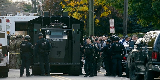 Law enforcement personnel gather at the scene where two officers were reported shot in Newark, New Jersey, on Tuesday.