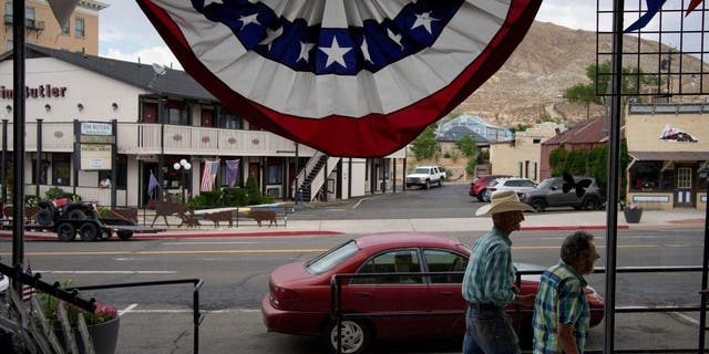 Mensen lopen langs de hoofdweg in de provinciehoofdstad van Nye County, 18 juli 2022, in Tonopah, Nevada. 
