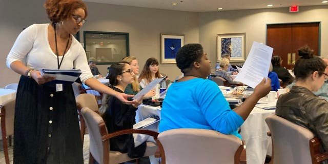 Carter Center employee Jordan McNairy collects signed codes of conduct from volunteer election observers training on Saturday, Nov. 5, 2022 at the Carter Center in Atlanta. 