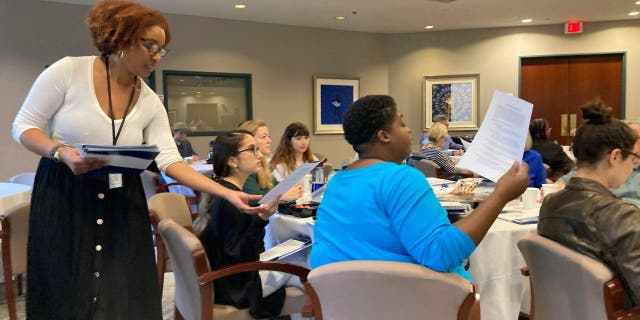 Carter Center employee Jordan McNairy collects signed codes of conduct from volunteer election observers training on Saturday, Nov. 5, 2022 at the Carter Center in Atlanta.