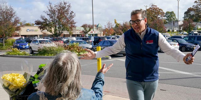 George Santos talks to a voter while campaigning on Nov. 5, 2022, in Glen Cove, New York.