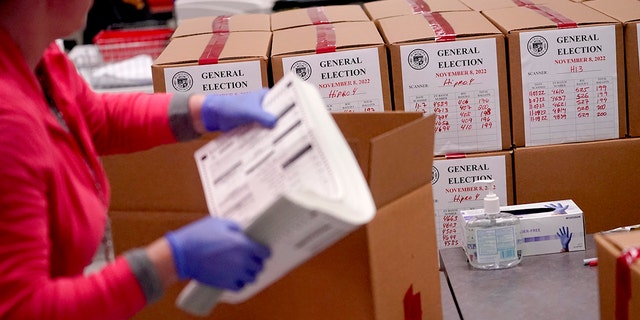 یک کارگر انتخاباتی، در دفتر ثبت اسناد شهرستان ماریکوپا، چهارشنبه، 9 نوامبر 2022، در فینیکس، برگه های رای را جدول بندی می کند. 