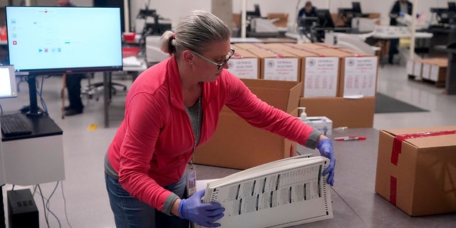 An election worker boxes tabulated ballots inside the Maricopa County Recorders Office, Wednesday, Nov. 9, 2022, in Phoenix. 
