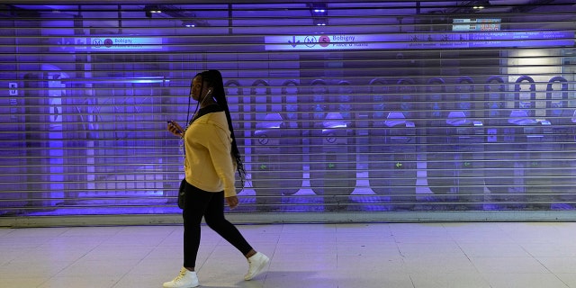 A woman walks in front of a closed metro station on Thursday, November 10, 2022, in Paris.