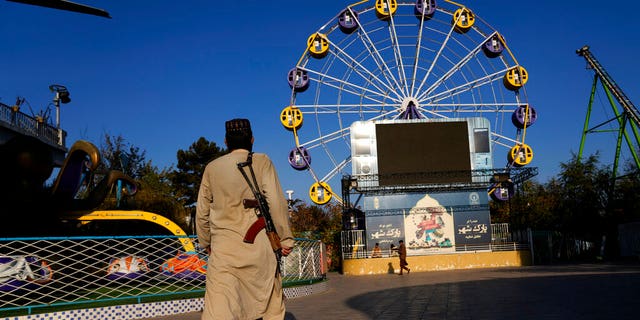 A Taliban fighter stands guard in an amusement park, in Kabul, Afghanistan, Thursday, Nov. 10, 2022.  The Taliban have banned women from using gyms and parks in Afghanistan, Thursday, Nov. 10. The rule, which comes into force this week, is the group's latest edict cracking down on women's rights and freedoms.