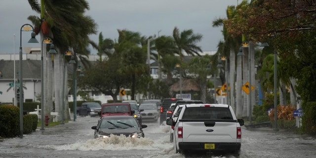 Drivers are driving in a flooded street after Hurricane Nicole on Thursday, November 10, 2022, in Fort Pierce, Florida.