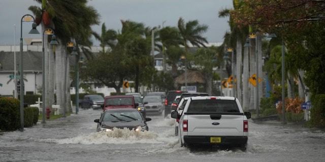 Drivers are driving in a flooded street after Hurricane Nicole on Thursday, November 10, 2022, in Fort Pierce, Florida.