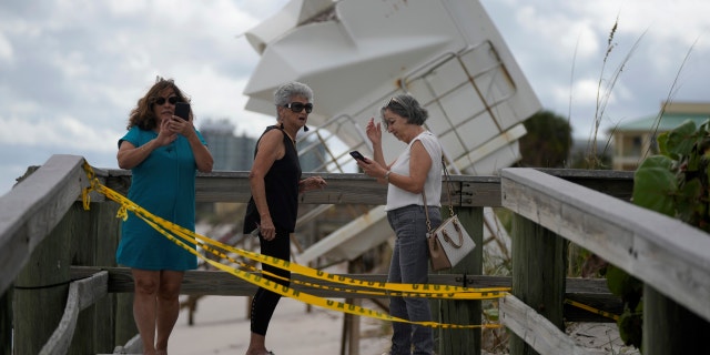 People visit the beach to investigate storm damage, including the rescue station that was moved to the dune after Hurricane Nicole on Thursday, November 10, 2022 in Vero Beach, Florida.