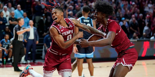 Temple's Khalif Battle, left, and Jahlil White celebrate during the final second of an NCAA college basketball game against Villanova, Friday, Nov. 11, 2022, in Philadelphia.