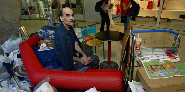 FILE - Merhan Karimi Nasseri sits among her belongings in Terminal 1 of Roissy Charles De Gaulle Airport, north of Paris, on August 11, 2004. 