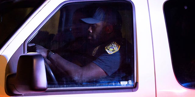 Un oficial de policía de la Universidad de Virginia conduce una camioneta llena de personas lejos de la escena del crimen durante una situación de tirador activo en el campus de la Universidad de Virginia en Charlottesville el lunes 14 de noviembre de 2022.