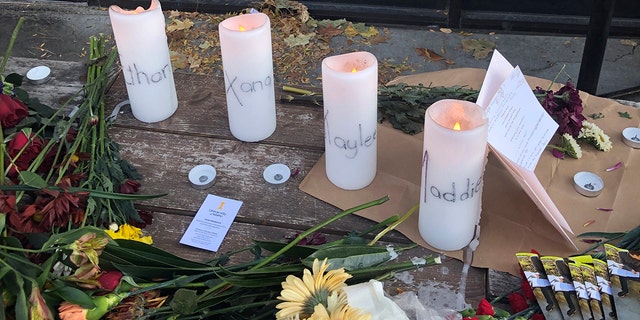 Candles and flowers are left at a make-shift memorial honoring four slain University of Idaho students outside the Mad Greek restaurant in downtown Moscow, Idaho, on Tuesday, Nov. 15, 2022. 