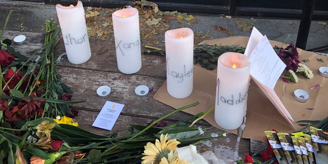 Candles and flowers are left at a make-shift memorial honoring four slain University of Idaho students outside the Mad Greek restaurant in downtown Moscow, Idaho, on Tuesday, Nov. 15, 2022. . 