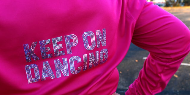 The words "Keep On Dancing" decorate the back of Kathi Schmeling’s jacket as she marches at a practice of the Milwaukee Dancing Grannies Nov. 2, 2022, in Milwaukee.