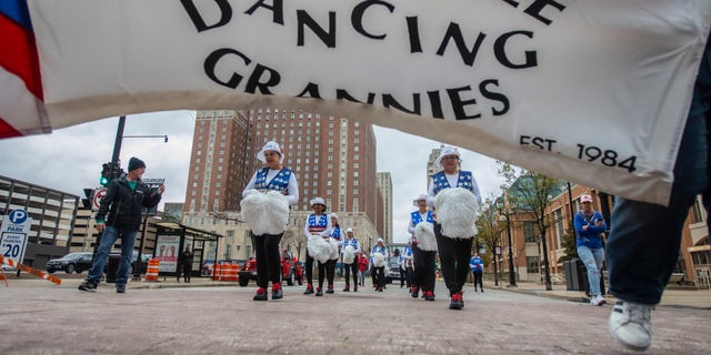 A banner for the Milwaukee Dancing Grannies flutters in the wind as the Grannies march in a Veterans Day parade in Milwaukee Nov. 5, 2022. 