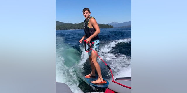 In this photo provided by Stacy Chapin, Ethan Chapin surfs on Priest Lake in northern Idaho in this family snapshot from July 2022. Chapin was one of four University of Idaho students found stabbed to death in a home near the Moscow, Idaho campus on Sunday, Nov. 13, 2022. 
