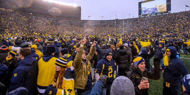Michigan fans celebrate on the Michigan Stadium field after the team's win over Ohio State in Ann Arbor, Mich., Nov. 27, 2021.