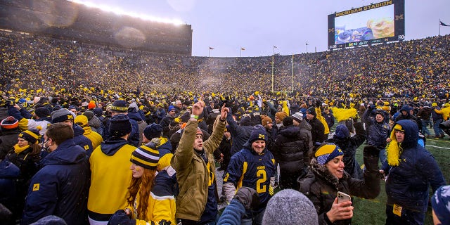 Michigan fans celebrate on the Michigan Stadium field after the team's win over Ohio State in Ann Arbor, Mich., Nov. 27, 2021.