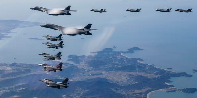 In this photo provided by South Korean Defense Ministry, two U.S. Air Force B-1B bombers, top center, South Korean Air Force F-35 fighter jets and US Air Force F-16 fighter jets, bottom left, fly over South Korea Peninsula during a joint air drill in South Korea, Saturday, Nov. 19, 2022. 