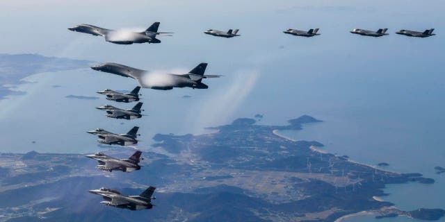 In this photo provided by the South Korean Defense Ministry, two US Air Force B-1B bombers, top center, South Korean Air Force F-35 fighter jets, and US Air Force F-16 fighter jets, bottom left, fly over the peninsula of South Korea during a joint air exercise in South Korea on Saturday, November 19, 2022. 