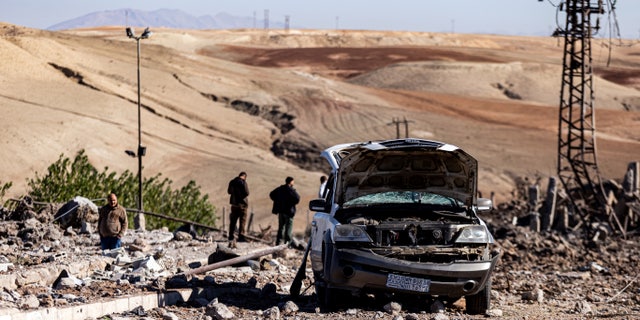 Burgers inspecteren een locatie die is beschadigd door Turkse luchtaanvallen op een elektriciteitscentrale in het dorp Naql Baqil in de Syrische provincie Hasakah, zondag 20 november 2022.