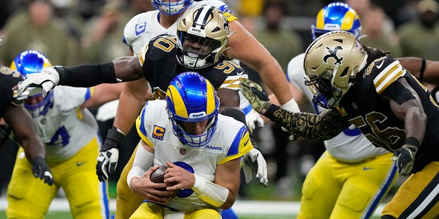 Los Angeles Rams quarterback Matthew Stafford is sacked by New Orleans Saints defenders Tanoh Kpassagnon (90) and Demario Davis (56) in the second half of a game in New Orleans Nov. 20, 2022. 