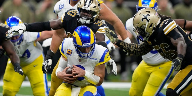 Los Angeles Rams quarterback Matthew Stafford is sacked by New Orleans Saints defenders Tanoh Kpassagnon (90) and Demario Davis (56) in the second half of a game in New Orleans Nov. 20, 2022. 