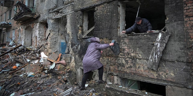 Люди забирают свои вещи из дома, пострадавшего в результате обстрела русскими в городе Вышгород, недалеко от Киева, Украина, четверг, 24 ноября 2022 года.