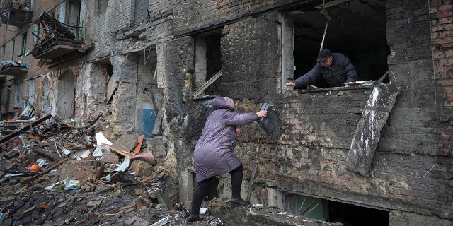 People gather their belongings from a damaged house after Russian shelling in the town of Vyshgorod, outside the capital Kyiv, Ukraine, Thursday, Nov. 24, 2022.