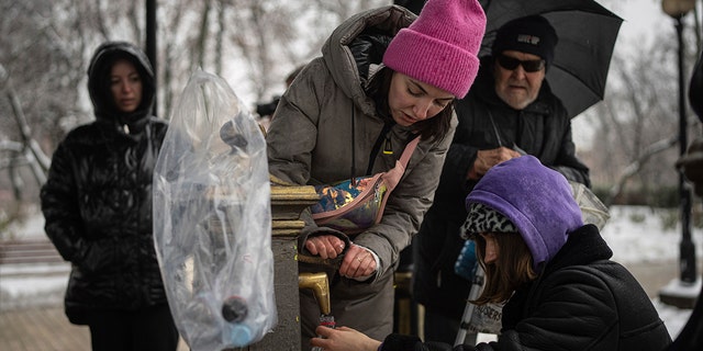 People collect water, in Kyiv, Ukraine, Thursday, Nov. 24, 2022. 