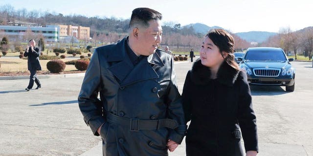In this undated photo provided by the North Korean government on Nov. 27, 2022, North Korean leader Kim Jong-un (L) and his daughter (R) walk for a photo session with those involved in the recent launch of what is said to be the Hwasong ICBM-17 at an unspecified location in North Korea.