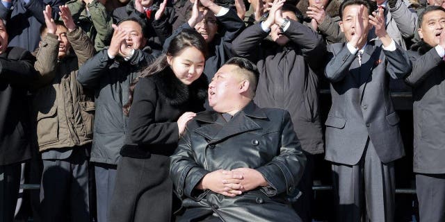 This undated photo provided on Nov. 27, 2022, by the North Korean government shows North Korean leader Kim Jong Un, center right, with his daughter, center left, pose with scientists and workers for a photo, following the launch of what it says a Hwasong-17 intercontinental ballistic missile, at an unidentified location in North Korea. 