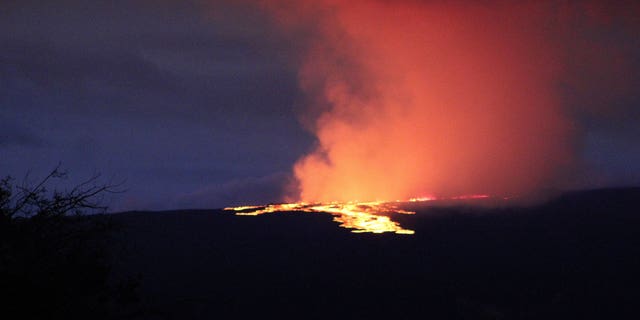Lava pours out of the summit crater of Mauna Loa about 6:35 a.m. Monday, Nov. 28, 2022, as seen from Gilbert Kahele Recreation Area on Maunakea, Hawaii. Mauna Loa, the world’s largest active volcano,  began spewing ash and debris from its summit, prompting civil defense officials to warn residents on Monday to prepare in case the eruption causes lava to flow toward communities.